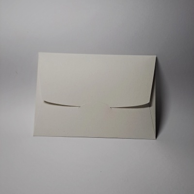 Envelope branco fechado sobre superfície branca lisa