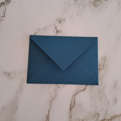 Envelope azul escuro sobre fundo de mármore branco