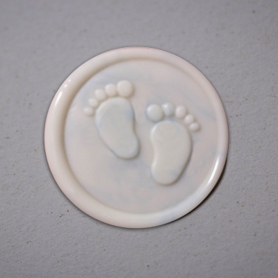 Selo branco redondo com pegadas em relevo sobre fundo cinza