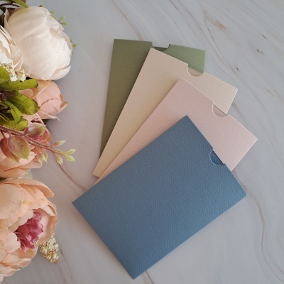 Conjunto de quatro envelopes texturizados em cores pastel com flores ao lado