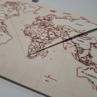 Mapa-múndi em tons de bege e castanho com agulha sobre África do Sul