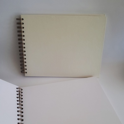 Dois cadernos de desenho com espiral e páginas em branco sobre fundo branco.