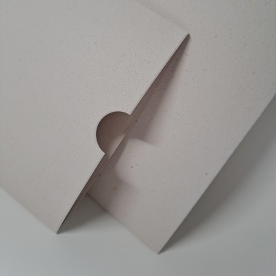 Embalagem de cartão off-white com recorte arredondado na aba