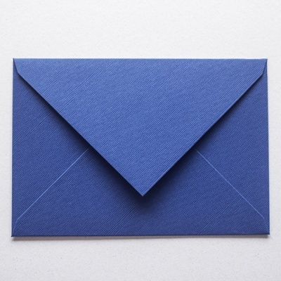 Envelope azul texturizado fechado sobre superfície clara