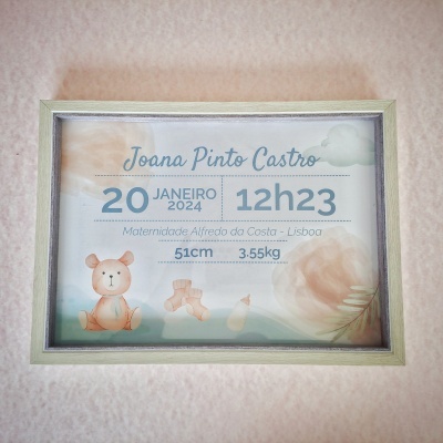 quadro decorativo de nascimento com moldura clara e texto de dados do bebê em azul e elementos infantis