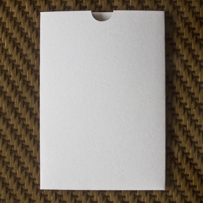 Envelope branco simples sobre superfície têxtil castanha com padrão entrelaçado