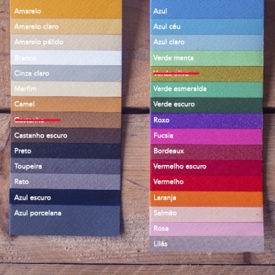 Cartelas de amostras de cor de tecido com vários tons e nomes em português sobre fundo de madeira