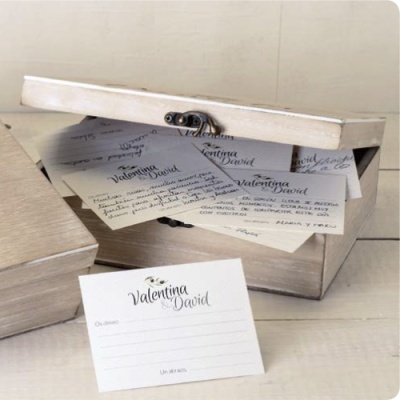 Caixa de madeira branca aberta com convites personalizados e cartão para preencher na frente
