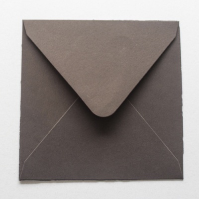 Envelope quadrado castanho escuro com aba triangular.