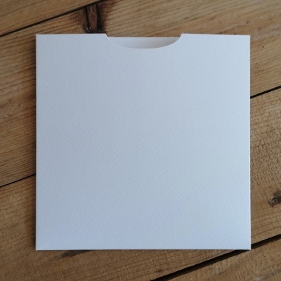 Envelope quadrado branco sobre fundo de madeira clara