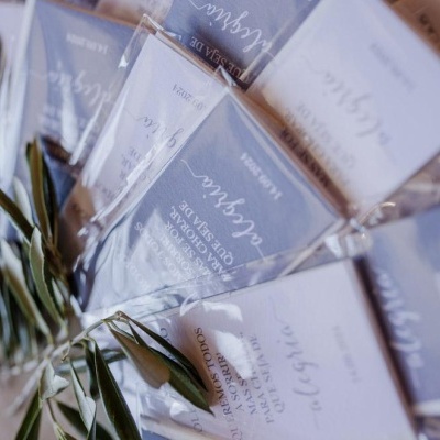 Pacotes de sabonetes artesanais com rótulos brancos e cinza e folhas verdes.