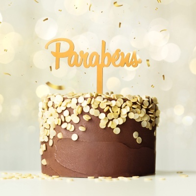 Bolo de chocolate com confeitos brancos e toppper dourado 'Parabéns'