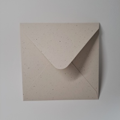 Envelope quadrado bege com textura de pontos pretos