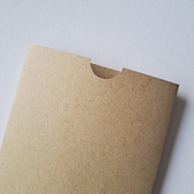 Embalagem de cartão castanho claro com aba arredondada e recorte semicircular