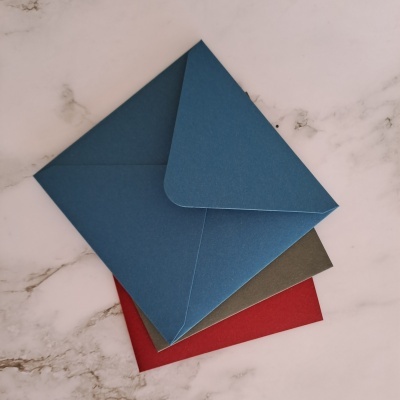 Envelopes coloridos empilhados sobre superfície marmoreada