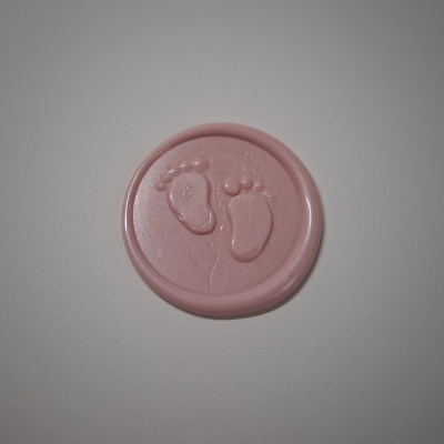 Selo de cera rosa com pegadas de bebé em relevo
