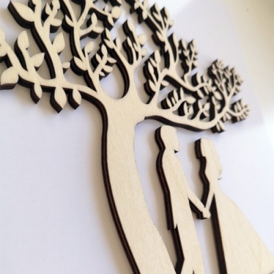 Decoração em madeira clara com árvore estilizada e casal de mãos dadas