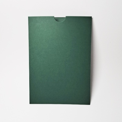 Envelope verde escuro liso sobre superfície branca