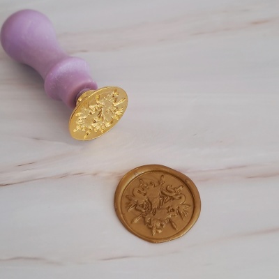 Carimbo de lacre roxo com base dourada e lacre de cera dourado