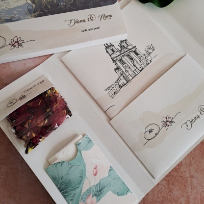 Convites de casamento em papel creme com texto Diana & Nuno e data 19 de julho 2026, e pacote com pétalas secas.