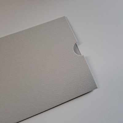 Envelope cinza claro com textura fina em superfície branca