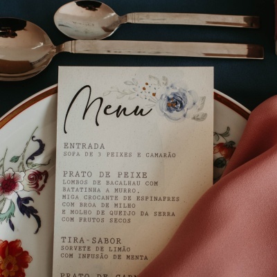 Cartão de menu com texto em português sobre prato decorado e guardanapo cor de rosa