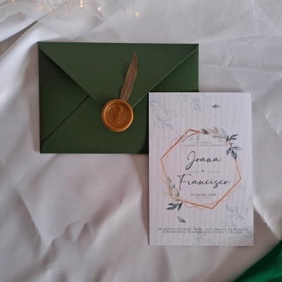 Convite de casamento com envelope verde, selo de cera e papel com texto e flores