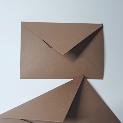 Dois envelopes castanhos em papel sobre superfície branca