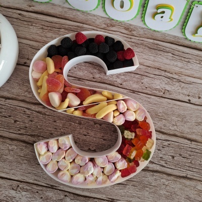 Recipiente em forma de S com gomas coloridas divididas em secções