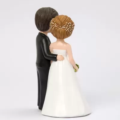 Figuras decorativas de noivos de costas, noivo em fato preto e noiva em vestido branco com cabelo decorado
