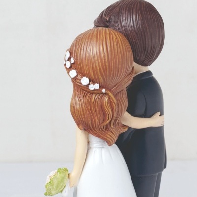 Figura decorativa de noivos de costas com vestido branco e fato preto