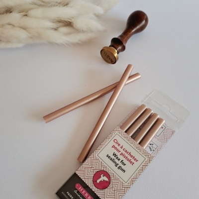 Palitos de lacre em embalagem com carimbo de madeira sobre superfície branca