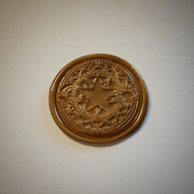 Selo de lacre redondo castanho com estrela em relevo