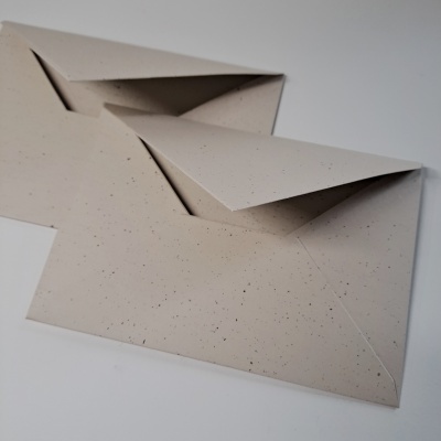 Dois envelopes de papel reciclado bege com pintas pretas
