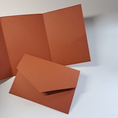Pastas ou envelopes terracota de papel texturizado sobre superfície branca