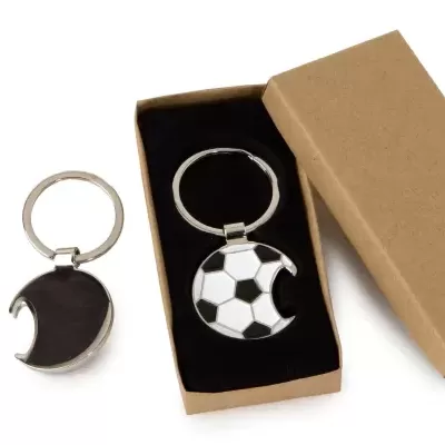 Dois porta-chaves redondos com padrão de bola de futebol, um dentro de caixa de cartão castanho