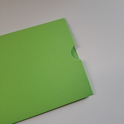 Envelope verde de papel texturizado com recorte semi-circular sobre fundo branco