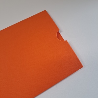 Envelope de papel ou cartão laranja com recorte semi-redondo