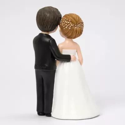 Estátua decorativa de casal de noivos vista de costas com vestido branco e fato preto