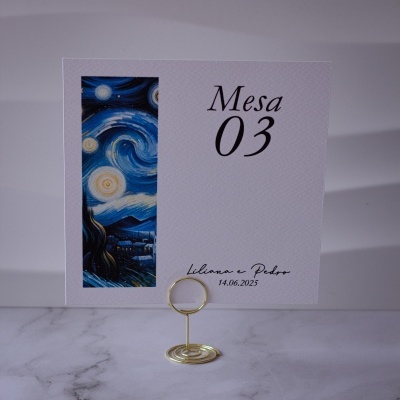 Cartão de mesa branco com número 03 e desenho inspirado em Noite Estrelada em suporte dourado sobre mármore