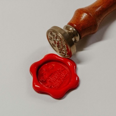 Carimbo de selo de cera com pega de madeira e selo de cera vermelho aplicado