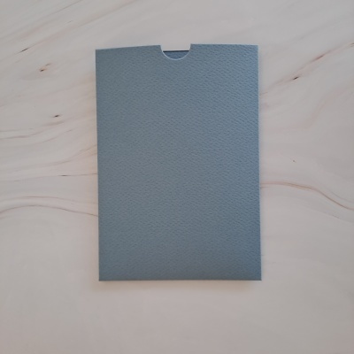 Envelope azul texturizado sobre superfície de madeira