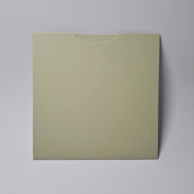 Envelope quadrado de papel reciclado verde claro sobre superfície branca