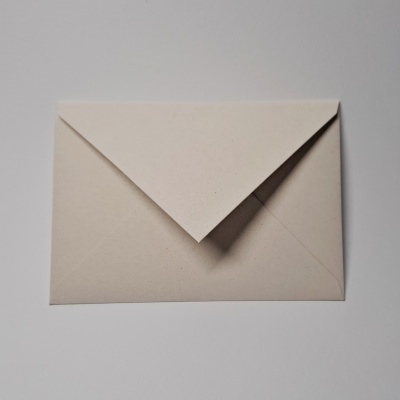 Envelope de papel branco fechado sobre uma superfície branca.