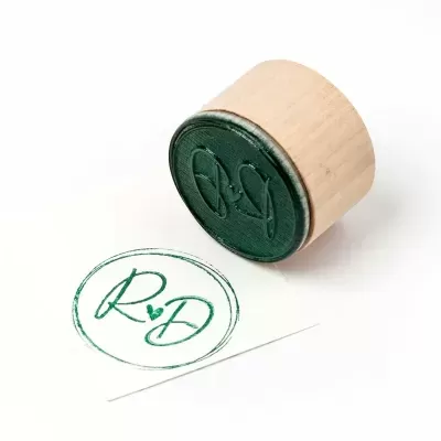 Carimbo redondo com letras R D e um coração no centro
