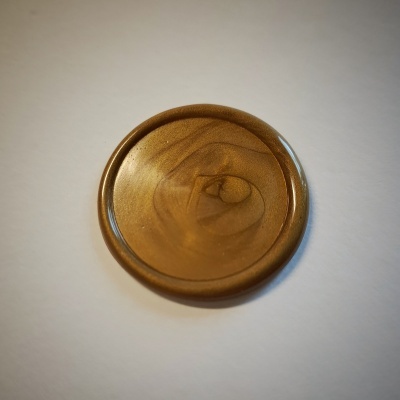 Disco redondo de plástico castanho translúcido com padrão ondulado.