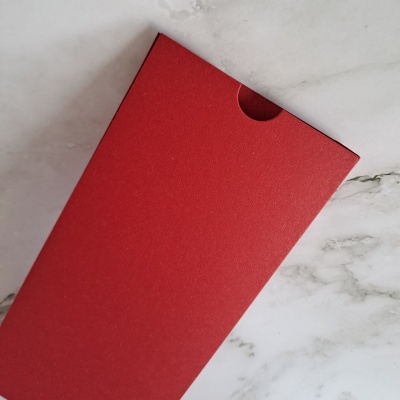 Caixa vermelha de cartão sobre superfície de mármore