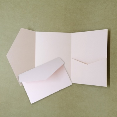 Conjunto de papelaria branco com pasta e envelope sobre fundo verde claro