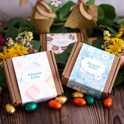 Caixas de presente de Páscoa com faixas decorativas e ovos de chocolate ao redor