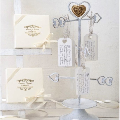 Caixas de presente brancas com laços e suporte metálico branco com etiquetas penduradas